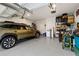 Attached garage with epoxy flooring, car, overhead lighting, and ample storage at 5685 Surprise Lily Dr, Winter Garden, FL 34787