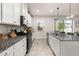 Bright kitchen featuring granite countertops, tile backsplash, stainless steel appliances, and white cabinets at 5685 Surprise Lily Dr, Winter Garden, FL 34787