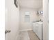 Clean laundry room featuring white washer and dryer units, window and storage shelf at 5685 Surprise Lily Dr, Winter Garden, FL 34787