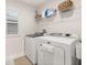 Convenient laundry room with white washer and dryer, shelving and natural light at 5685 Surprise Lily Dr, Winter Garden, FL 34787