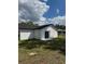 View of the back of the home and the backyard with sliding glass door at 6 Bahia Course Ln, Ocala, FL 34472