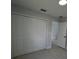 Bedroom with a four-panel closet door, neutral paint, and an open door to the house at 6 Bahia Course Ln, Ocala, FL 34472