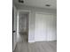 Bedroom with a four-panel closet door, neutral paint, and an open door to the house at 6 Bahia Course Ln, Ocala, FL 34472