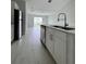 Modern kitchen with stainless steel appliances, white cabinets, and an island overlooking the living space at 6 Bahia Course Ln, Ocala, FL 34472