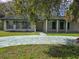 Inviting one-story brick home featuring a columned front porch and lush green lawn, perfect for Gathering living at 616 N Palm Ave, Kissimmee, FL 34741