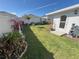 Backyard featuring green grass, flowering plants, and a serene water fountain at 676 Tanaro Ln, Haines City, FL 33844