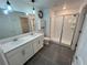 Modern bathroom with dual sinks, white cabinets, and a glass-enclosed shower at 676 Tanaro Ln, Haines City, FL 33844