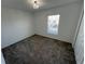 Bright bedroom with plush carpet, a window with blinds, and a decorative ceiling light at 676 Tanaro Ln, Haines City, FL 33844