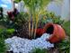 Beautiful front yard with decorative rock accents, lush plants, and vibrant flowers creating an eye-catching curb appeal at 676 Tanaro Ln, Haines City, FL 33844