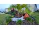 Charming front yard showcasing decorative rock accents, lush plants, and vibrant flowers, enhancing curb appeal and welcoming guests at 676 Tanaro Ln, Haines City, FL 33844