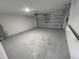 Spacious, empty garage with a clean, painted floor and an automatic door, ready for parking or storage at 676 Tanaro Ln, Haines City, FL 33844