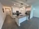 Open-concept kitchen with a large island, stainless steel appliances, and modern white cabinetry at 676 Tanaro Ln, Haines City, FL 33844
