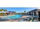 Community pool area featuring palm trees, lounge chairs, and a covered seating area at 676 Tanaro Ln, Haines City, FL 33844