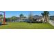 Community pool area showcasing palm trees, lounge chairs, and splash pad at 676 Tanaro Ln, Haines City, FL 33844