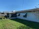 Backyard featuring green grass, white fencing, screened-in patio and a wooden bench at 706 Francis St, Kissimmee, FL 34741