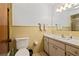 Bathroom featuring yellow tile, vanity, sink, mirror, and toilet at 706 Francis St, Kissimmee, FL 34741