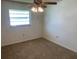 Cozy bedroom showcasing carpet flooring, a ceiling fan, and a window for natural lighting at 706 Francis St, Kissimmee, FL 34741