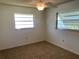 Bright bedroom with plush carpet, two windows and neutral paint at 706 Francis St, Kissimmee, FL 34741