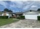Charming single-story home features a brick accent, well-manicured lawn, and attached garage at 706 Francis St, Kissimmee, FL 34741