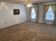 Spacious living room with carpet flooring and two windows dressed with curtains at 706 Francis St, Kissimmee, FL 34741
