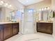 Bright bathroom featuring double sinks with granite countertops and a glass-enclosed walk-in shower at 741 Villa Park Rd, Poinciana, FL 34759