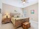 Bedroom with a queen bed, wooden chest and matching nightstands with beach themed decor at 741 Villa Park Rd, Poinciana, FL 34759