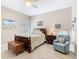 Cozy bedroom features a wooden bed frame, a blue armchair, soft lighting, and neutral colored walls at 741 Villa Park Rd, Poinciana, FL 34759
