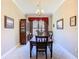 Formal dining room featuring a dark wood table, matching china cabinet, and window with red valance at 741 Villa Park Rd, Poinciana, FL 34759