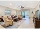 Spacious living room with tile floors, comfortable seating, and a view of the screened-in lanai at 741 Villa Park Rd, Poinciana, FL 34759