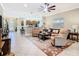Open-concept living room with tile flooring, ceiling fan, and comfortable seating with view to the kitchen at 741 Villa Park Rd, Poinciana, FL 34759