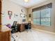 Functional home office with a large window, tile flooring, and a wooden desk with two office chairs at 741 Villa Park Rd, Poinciana, FL 34759