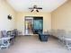 Large covered patio with fan, furniture, and sliding door into home at 741 Villa Park Rd, Poinciana, FL 34759
