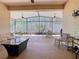 Large covered patio featuring outdoor furniture, ceiling fans, and a screened enclosure at 741 Villa Park Rd, Poinciana, FL 34759