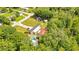 A cozy property with a pool, several outbuildings, and parking surrounded by mature trees, as seen from an aerial view at 78 N 5Th St, Orlando, FL 32833