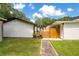 Fenced backyard with green grass, stone walkway, and white siding at 78 N 5Th St, Orlando, FL 32833