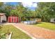 Backyard featuring a path to a red shed, a patio, and a pool surrounded by lush greenery at 78 N 5Th St, Orlando, FL 32833