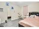 A relaxing bedroom with a pink comforter on the bed, a mirror, a vanity and a window with sheer pink curtains at 78 N 5Th St, Orlando, FL 32833