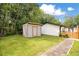 Backyard featuring a storage shed with neutral siding, brick pavers, and partial fencing at 78 N 5Th St, Orlando, FL 32833