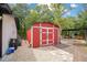 A red storage shed with double doors offers additional space for tools and equipment at 78 N 5Th St, Orlando, FL 32833