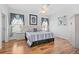 Comfortable bedroom features hardwood floors, a ceiling fan, and two windows for natural light at 8063 King Palm Cir, Kissimmee, FL 34747