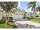 Charming single-Gathering home with a well-manicured lawn and a two-car garage on a sunny day at 8063 King Palm Cir, Kissimmee, FL 34747