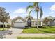 Charming single-story home featuring a well-manicured lawn, palm tree, and attached two-car garage at 8063 King Palm Cir, Kissimmee, FL 34747