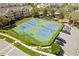 Aerial view of community tennis courts with lights, green space, parking, and a playground at 8063 King Palm Cir, Kissimmee, FL 34747