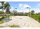 A sandy volleyball court with lights and landscaping next to a multi-Gathering building at 8063 King Palm Cir, Kissimmee, FL 34747