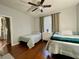 Cozy bedroom with a ceiling fan, two twin beds, natural light, and hardwood floors at 8300 Elm Park Dr # 7110, Orlando, FL 32821