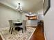 Elegant dining room area leading to the kitchen, with a modern chandelier and stylish rug at 8300 Elm Park Dr # 7110, Orlando, FL 32821