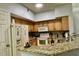 A kitchen featuring granite countertops, stainless steel appliances, and wood cabinets at 8300 Elm Park Dr # 7110, Orlando, FL 32821