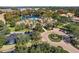 Aerial view of community pool, clubhouse, and parking with mature trees and landscaping at 8300 Portofino Dr # 403, Davenport, FL 33896