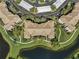 Overhead view of a residential building, highlighting the surrounding lawns and pond at 8300 Portofino Dr # 403, Davenport, FL 33896