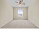Bright, empty bedroom featuring neutral carpet, ceiling fan, and large window at 8300 Portofino Dr # 403, Davenport, FL 33896
